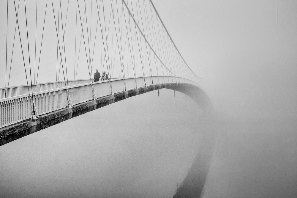 Menschen auf einer nebligen Brücke von Krunoslav Nevistic