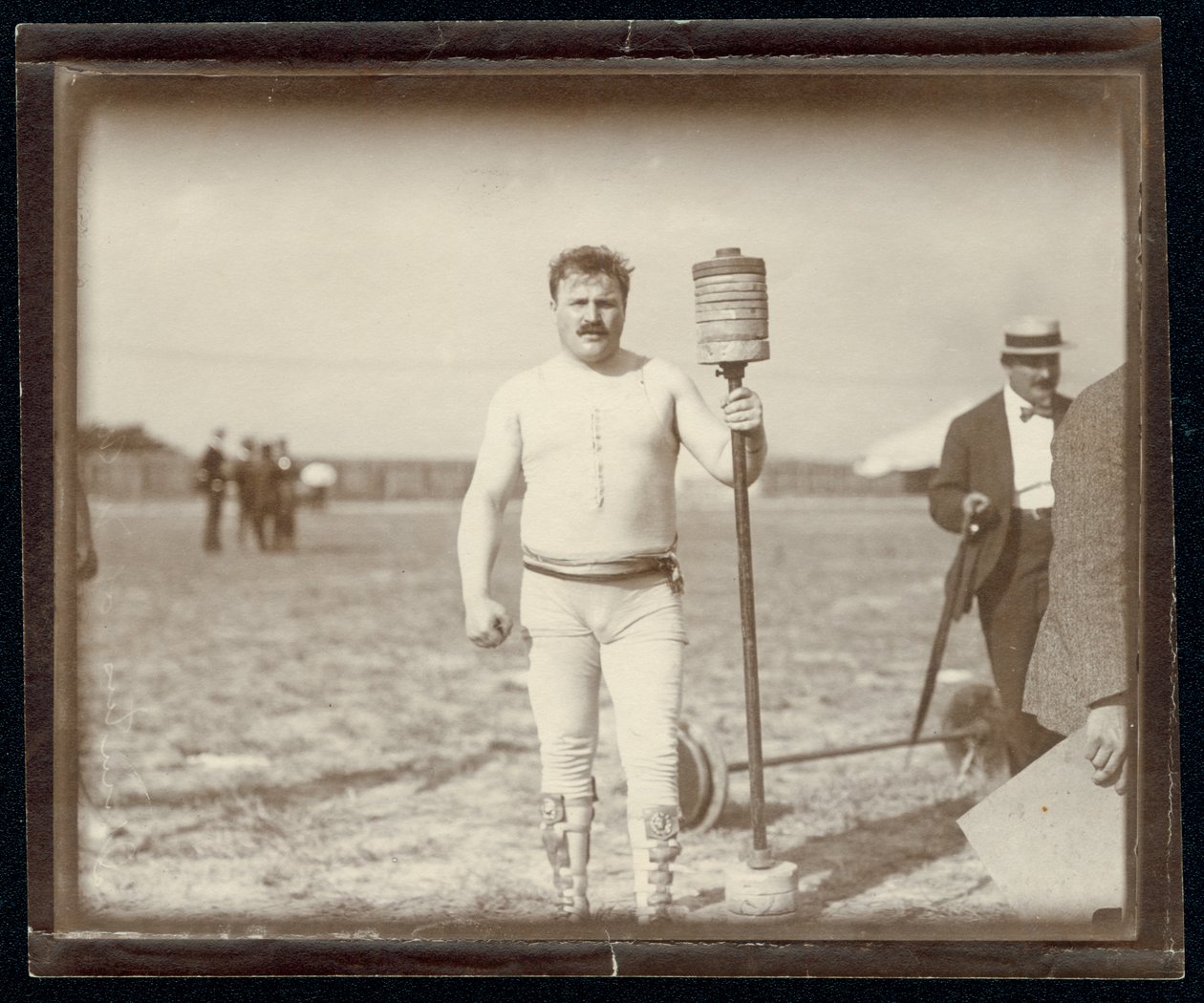 Fred Winters, Teilnehmer am Gewichtheberwettbewerb bei den Olympischen Spielen 1904, posiert mit Gewichten von Unknown
