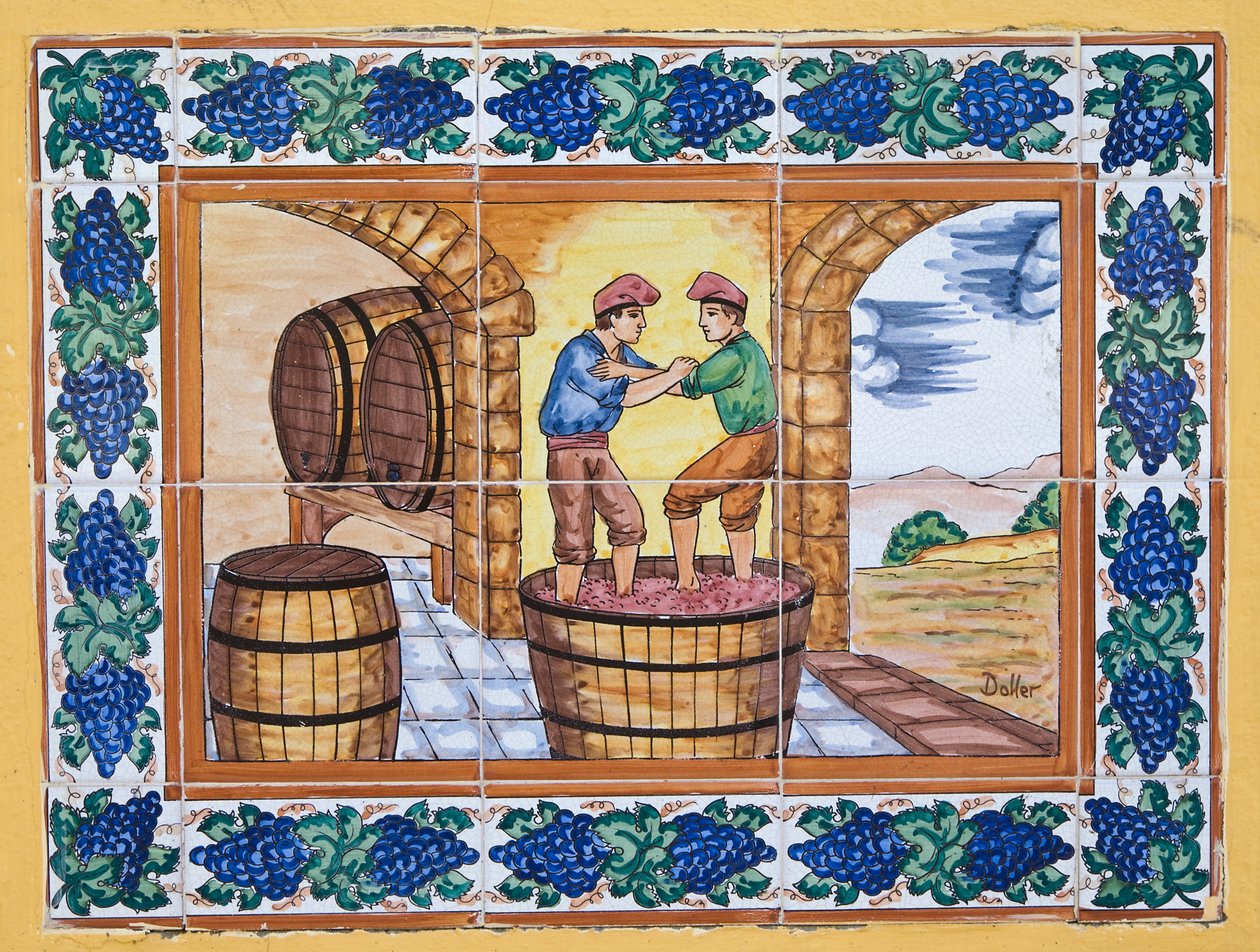 Moderne spanische Keramikfliesen im Stil des 17. oder 18. Jahrhunderts, die Arbeiter zeigen, die Trauben in einem Bottich im Weinkeller stampfen von Unknown