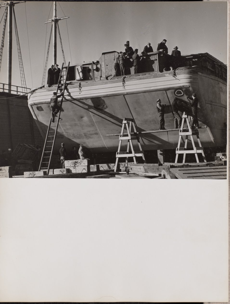 Eine Gruppe von Männern arbeitet an einem angedockten Boot von Arnold Eagle
