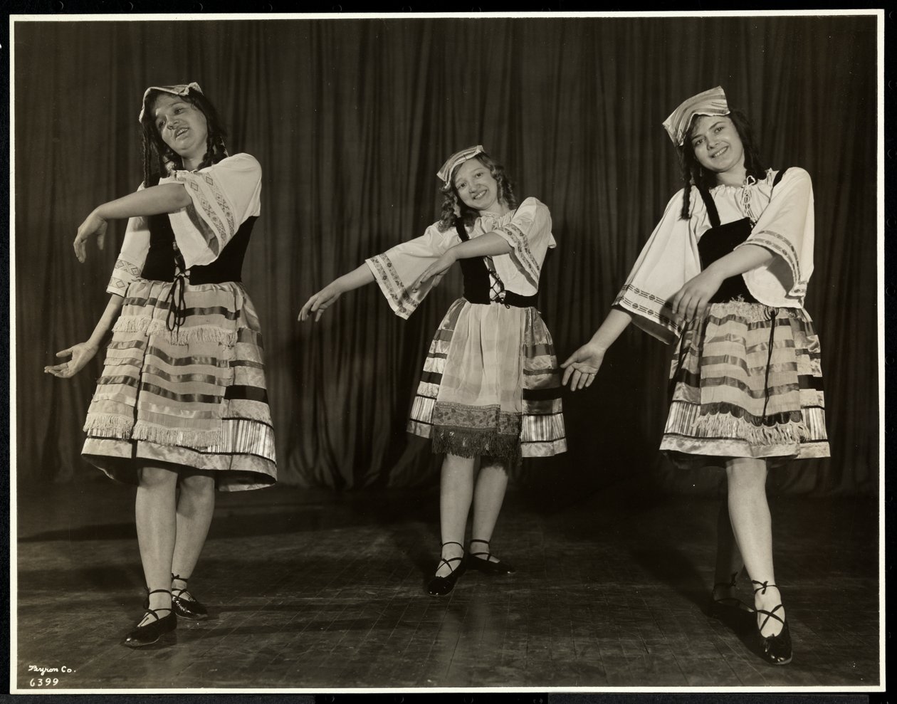 Drei blinde junge Frauen in Kostümen tanzen auf der Bühne in einem Stück der New York Association for the Blind, New York, 1931 von Byron Company