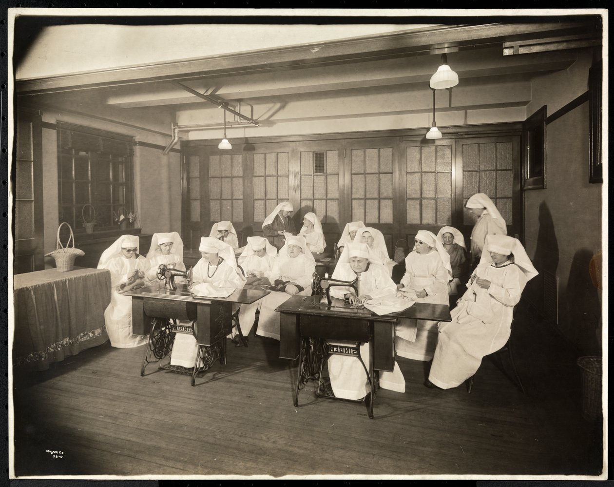 Frauen in weißen Kitteln, in einem Nähkurs, vermutlich während oder im Zusammenhang mit dem Ersten Weltkrieg, New York, ca. 1920 von Byron Company