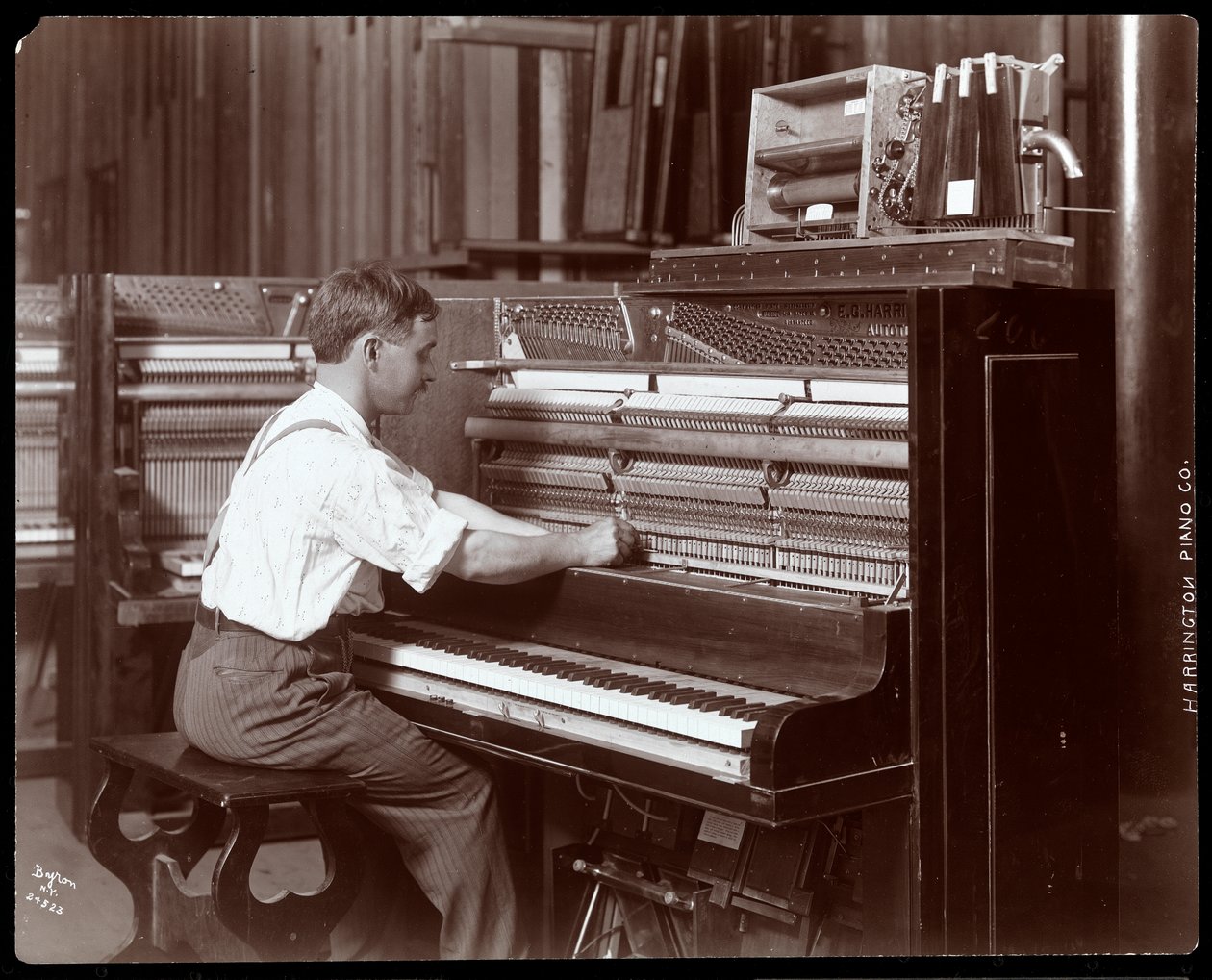 Ein Mann arbeitet in der Harrington Piano Co. Fabrik, 1907 von Byron Company