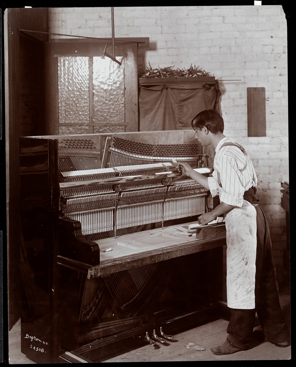Mann arbeitet in der Hardman, Peck und Co. Klavierfabrik, New York, 1907 (Silbergelatineabzug) von Byron Company