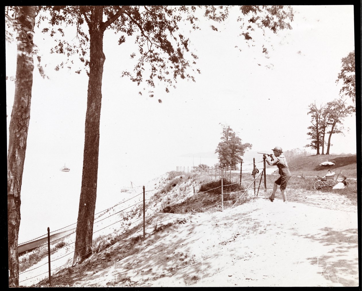 Ansicht eines Jungen mit Fernrohr, der vom Riverside Park in New York auf den Hudson River blickt von Byron Company