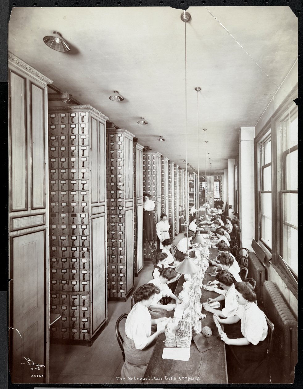 Frauen arbeiten in einem Aktenraum unter männlicher Aufsicht bei der Metropolitan Life Insurance Co. in der 23rd Street und Madison Avenue, 1907 von Byron Company
