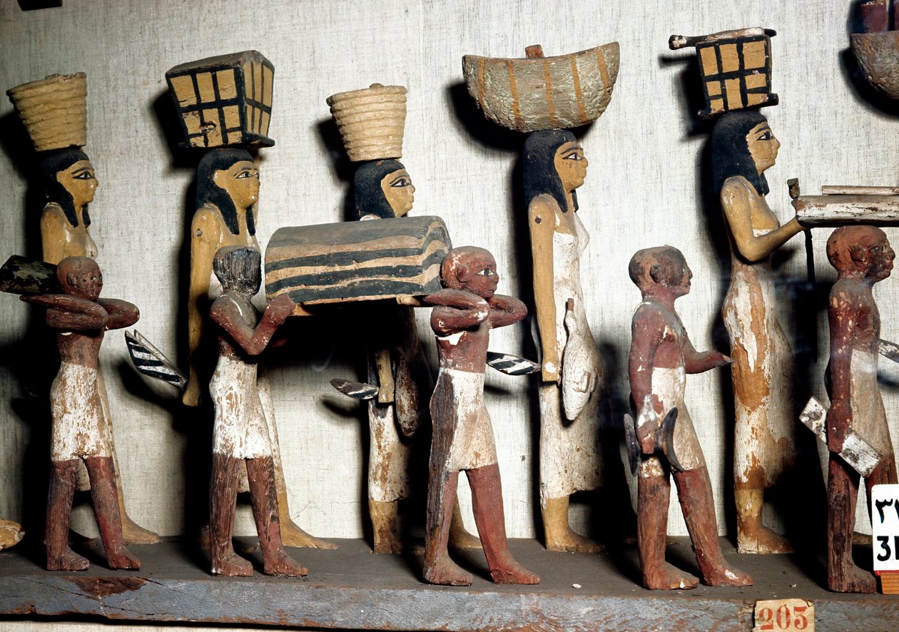 Ägyptische Antiquität: Eine geschnitzte Gruppe aus bemaltem Holz, die Diener darstellt, die dem Verstorbenen Opfergaben bringen. Kairo, Ägyptisches Museum von Egyptian Egyptian