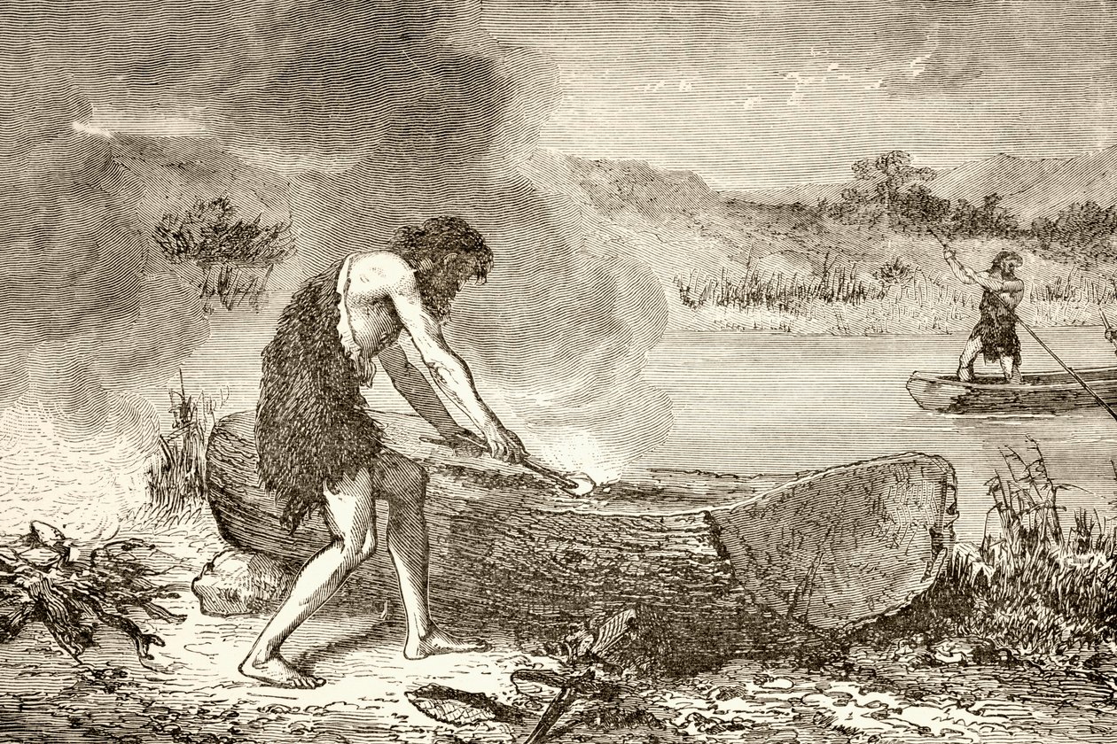 Ein prähistorischer Mann benutzt Feuer, um ein Kanu aus einem Baumstamm zu formen von English School
