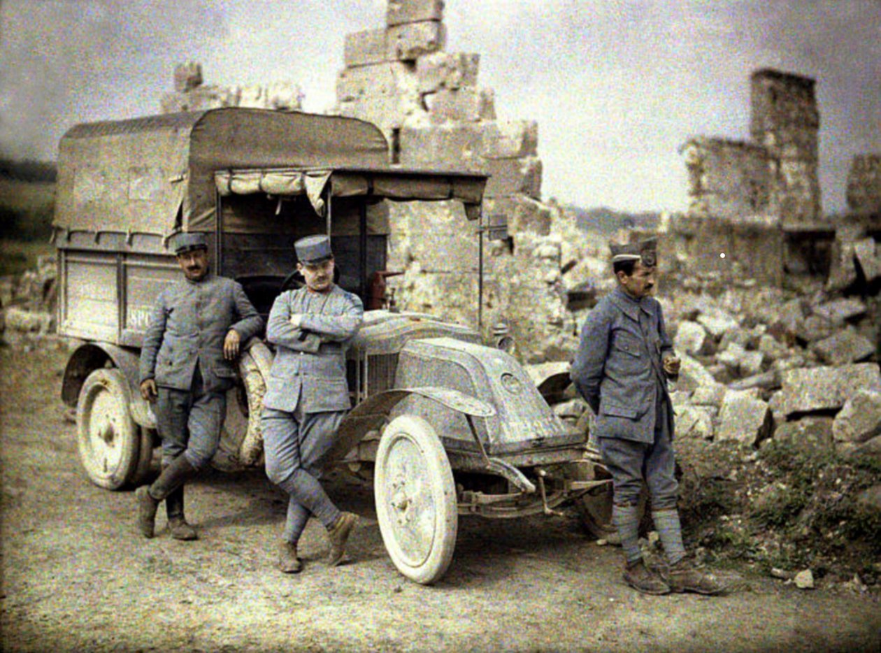 Drei französische Soldaten vor einem stark beschädigten Gebäude mit einem kleinen Lastwagen, Aisne, Frankreich, 1917 von Fernand Cuville