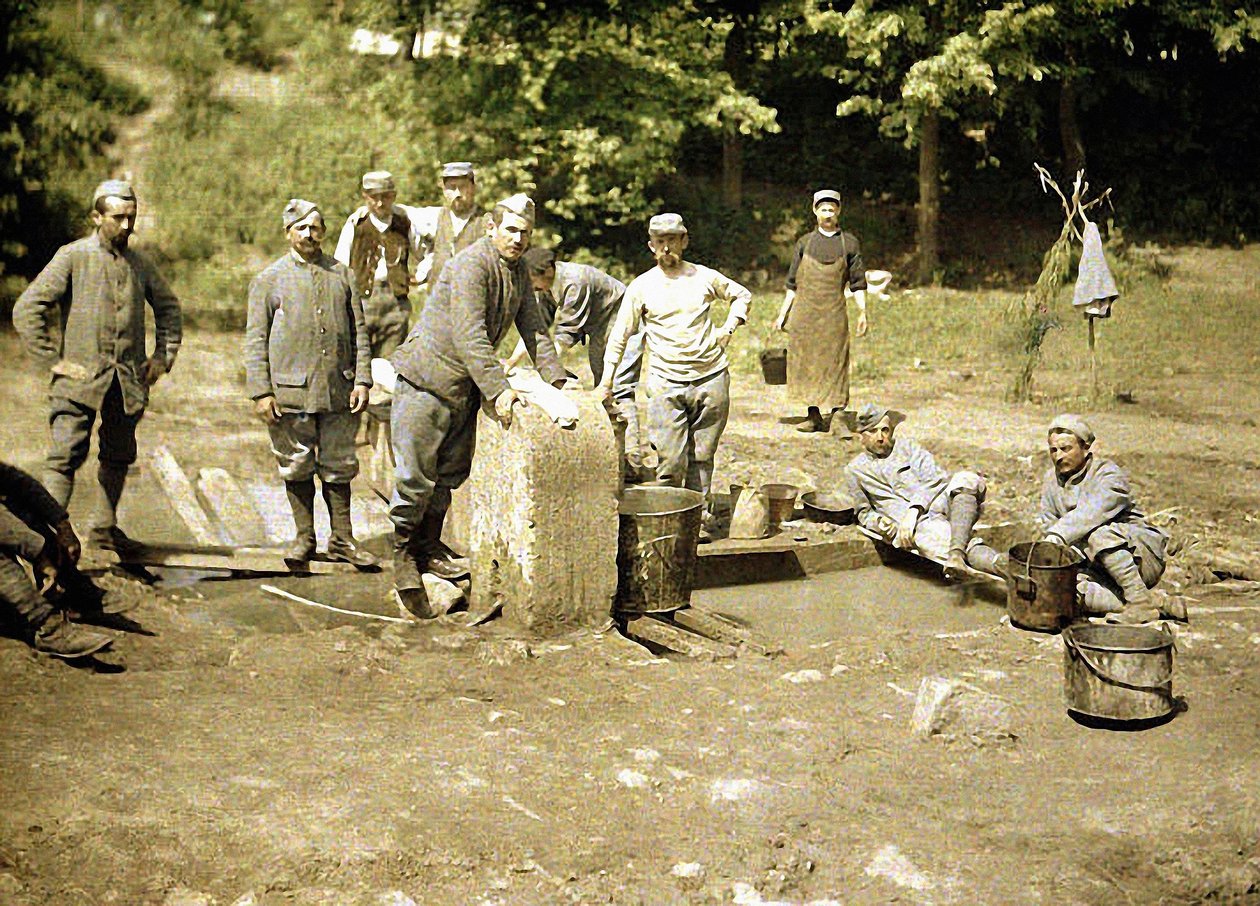 Gruppe französischer Soldaten beim Wäschewaschen an einem Brunnen, Soissons, Aisne, 1917 von Fernand Cuville