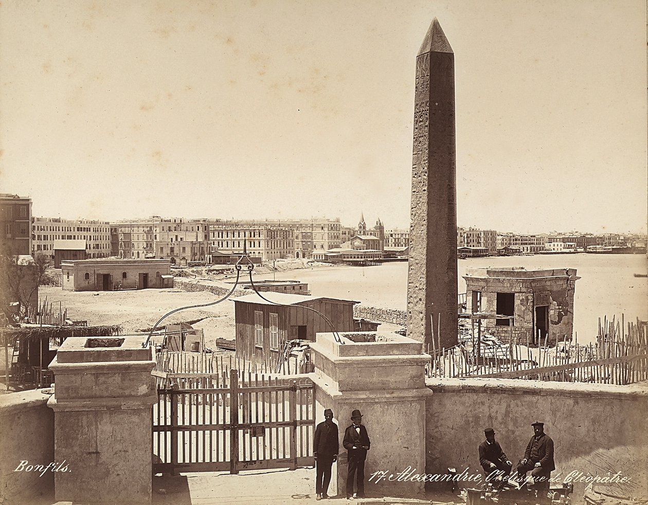 Alexandria, Ägypten: der Obelisk der Kleopatra, mit vier Männern, die für das Foto posieren von Félix Bonfils