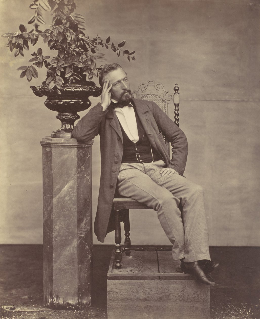 Mathias Höusermann, sitzend mit Ellbogen auf Sockel, hält eine Vase mit Blumen von Franz Antoine