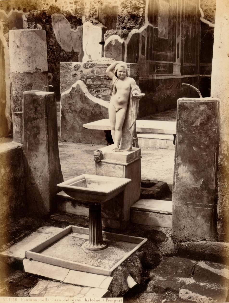 Ein Brunnen, bestehend aus einer Skulptur eines nackten Jungen. Der Brunnen befindet sich im Haus des Balcone pensile in Pompeji von Giorgio Sommer