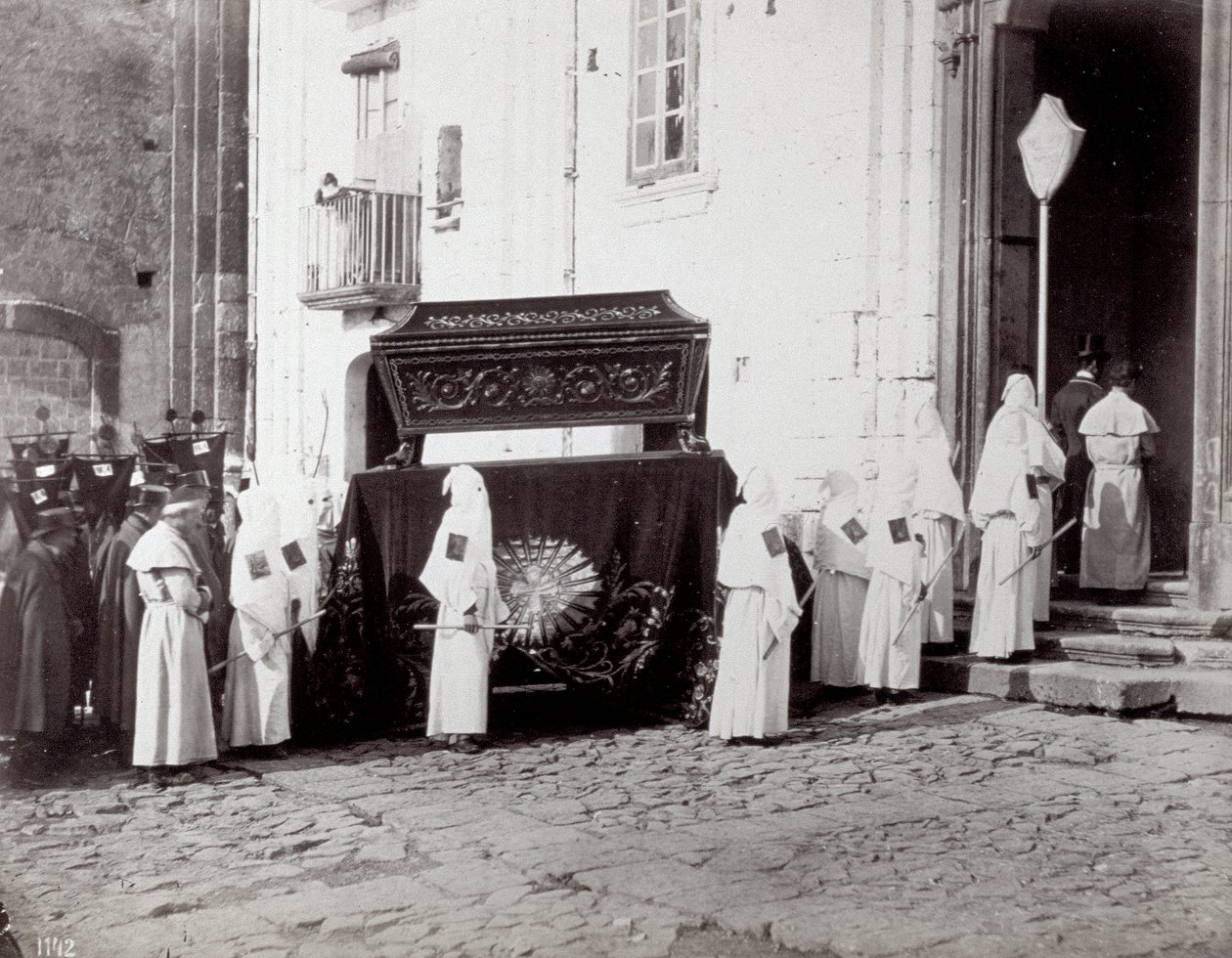 Begräbnisprozession der Kongregation von San Francesco in Neapel. Im Vordergrund, vor einer Kirche, begleiten zahlreiche 