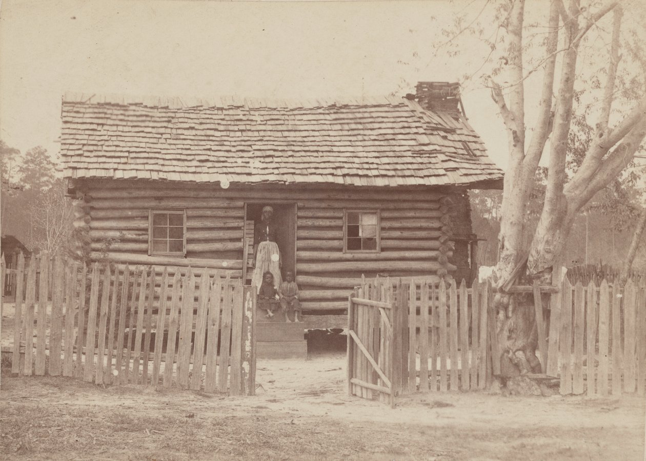 Albuminabzug einer Frau und zwei Kinder vor einem Blockhaus in Georgia, 1880er Jahre von H. S. Clark