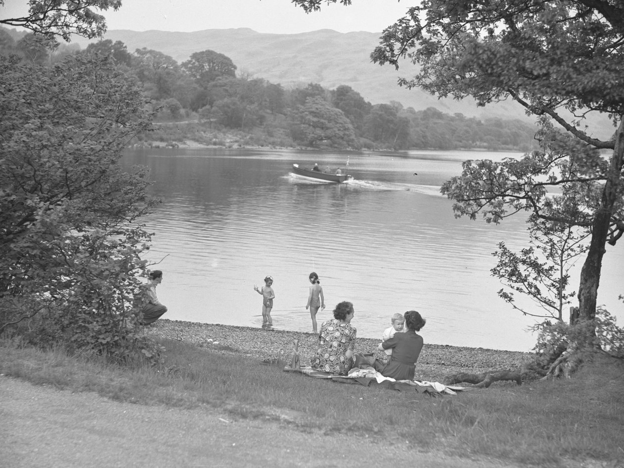Eine Familie genießt sich neben einem See, Boot auf dem See, Hügel im Hintergrund von Joseph Hardman