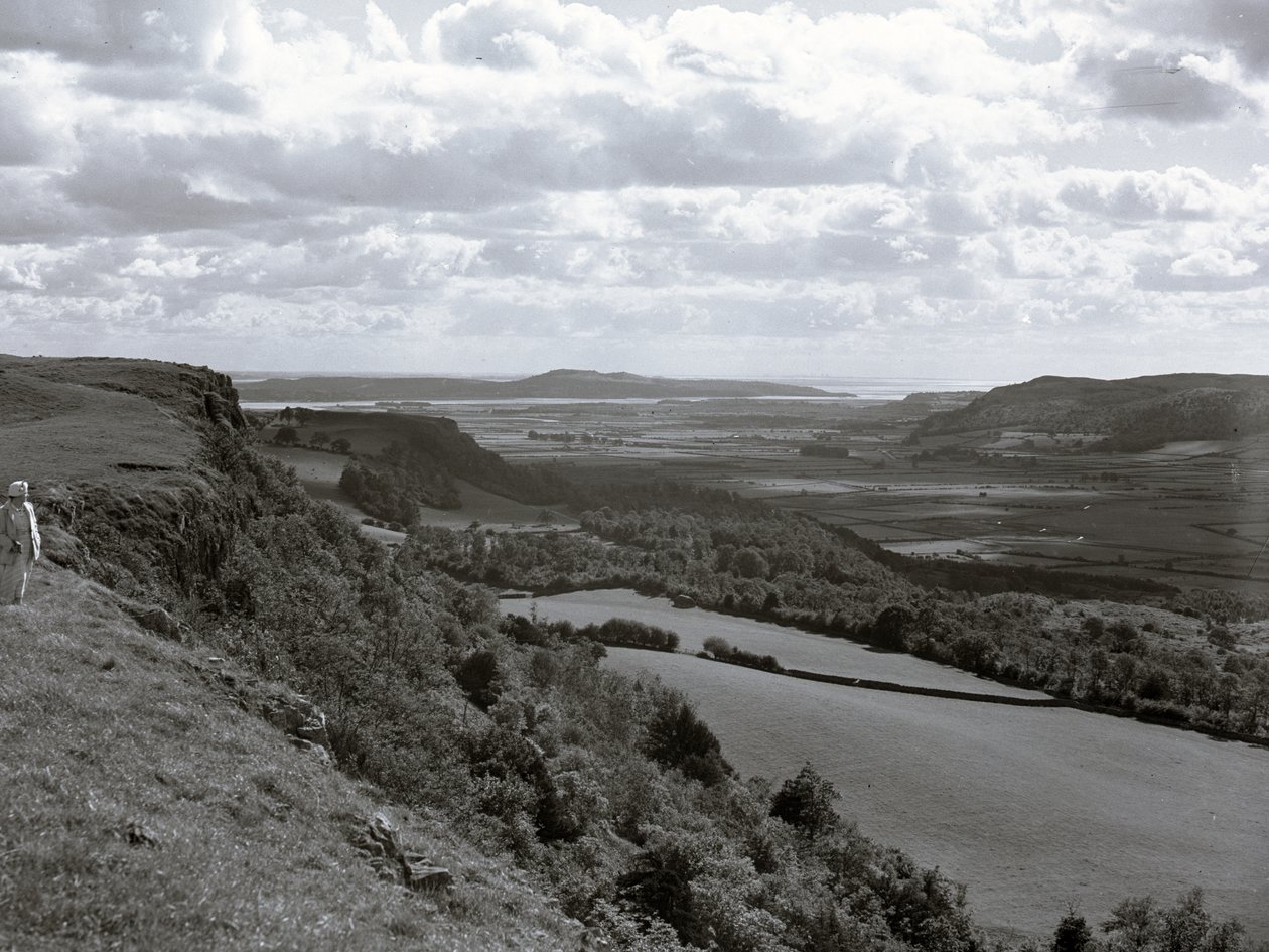 Eine Dame steht auf einem Hügel und blickt über die Landschaft bei Scout Scar von Joseph Hardman