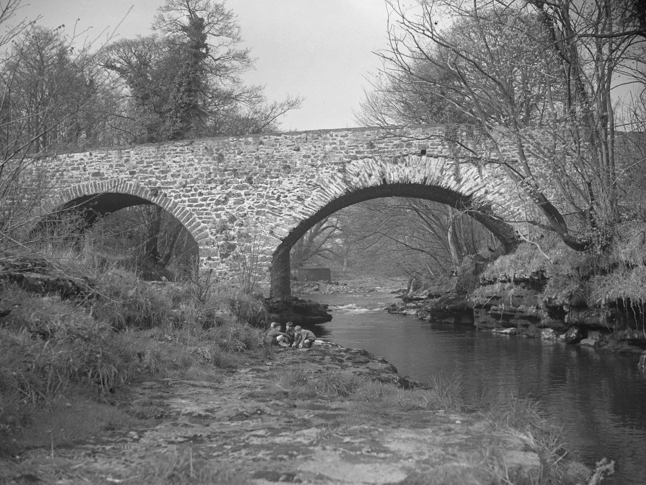 Gruppe von Jungen hockt am Flussufer unter einer Steinbrücke von Joseph Hardman