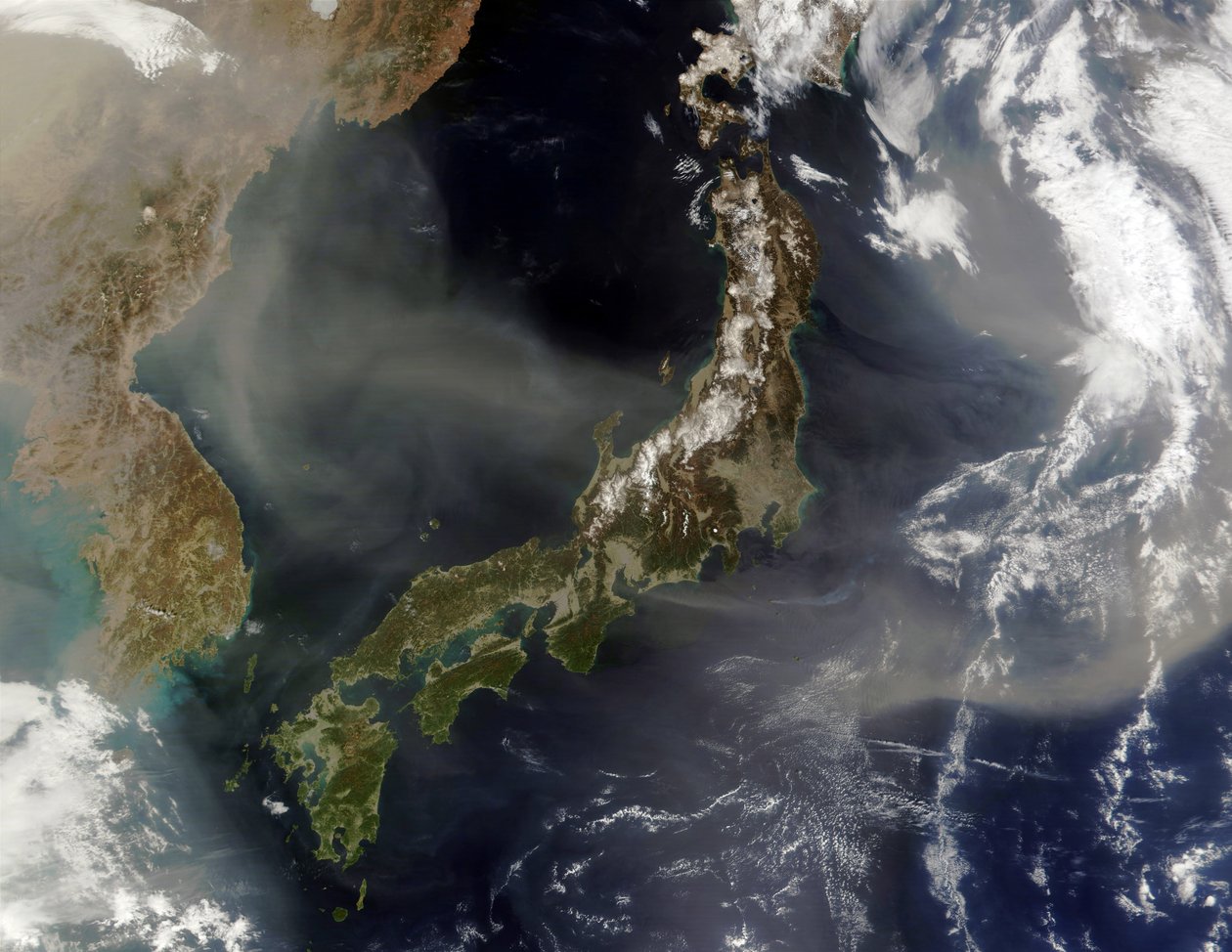 Satellitenansicht von Japan mit schneebedeckten Bergen, Frühlingsbegrünung auf niedrigeren Ebenen. Staub aus dem chinesischen Festland weht über das Japanische Meer und hinaus in den Pazifik. Wissenschaft Geologie von National Aeronautics and Space Administration National Aeronautics and Space Administration