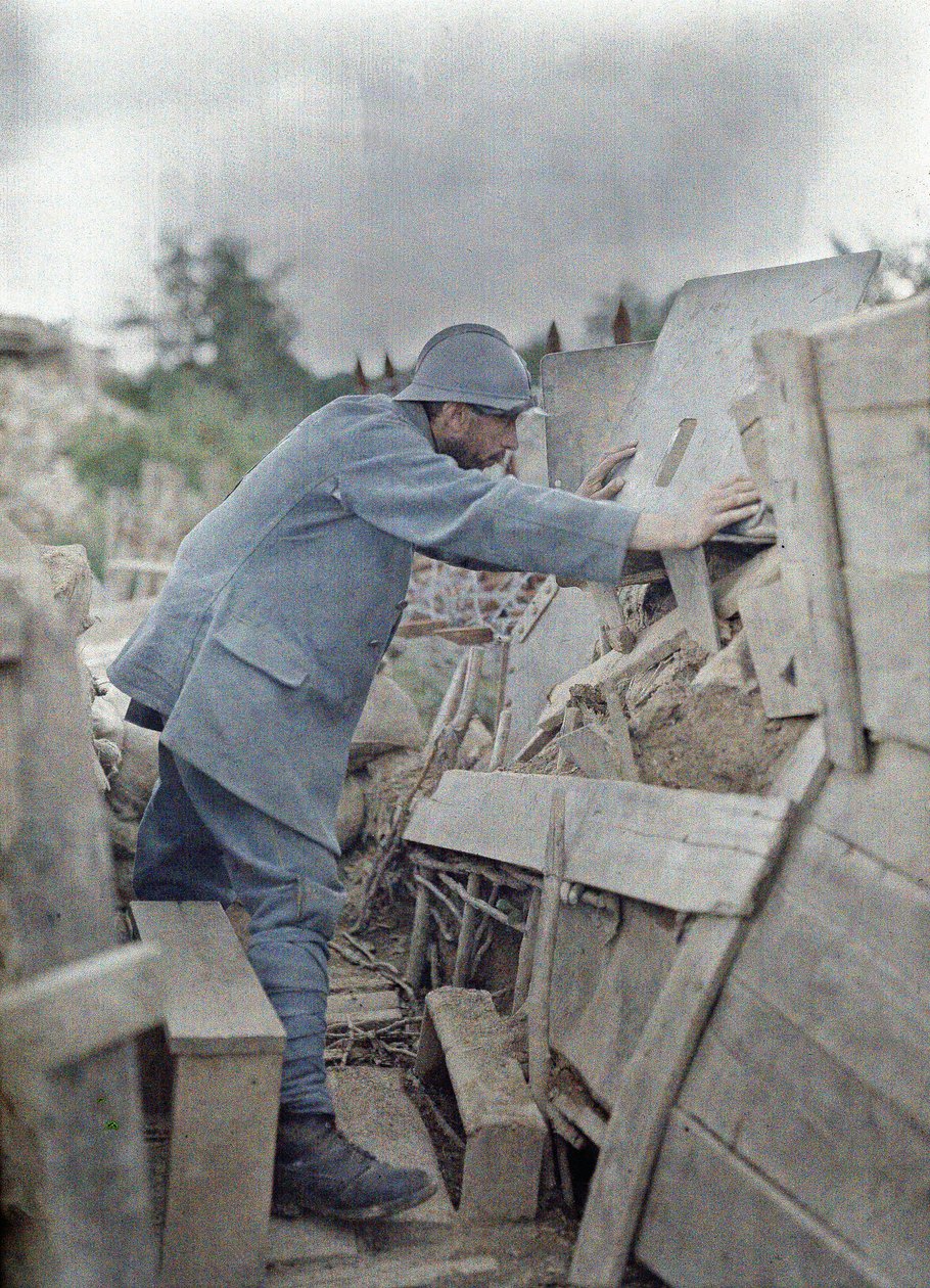 Ein französischer Soldat in der Armeebeobachtungsstation 26 betrachtet das Gebiet vor ihm durch einen Schutzschild aus Metall, Eglingen, Département Haut-Rhin, Elsass, Frankreich, 26. Juni 1917 von Paul Castelnau