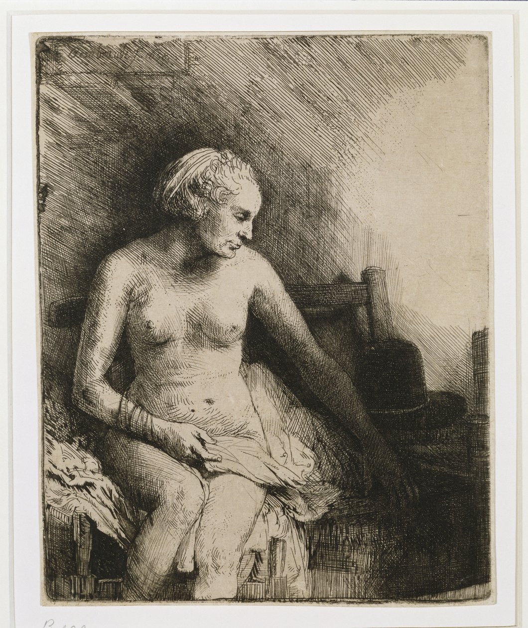 Eine Frau beim Bad mit einem Hut neben ihr von Rembrandt van Rijn