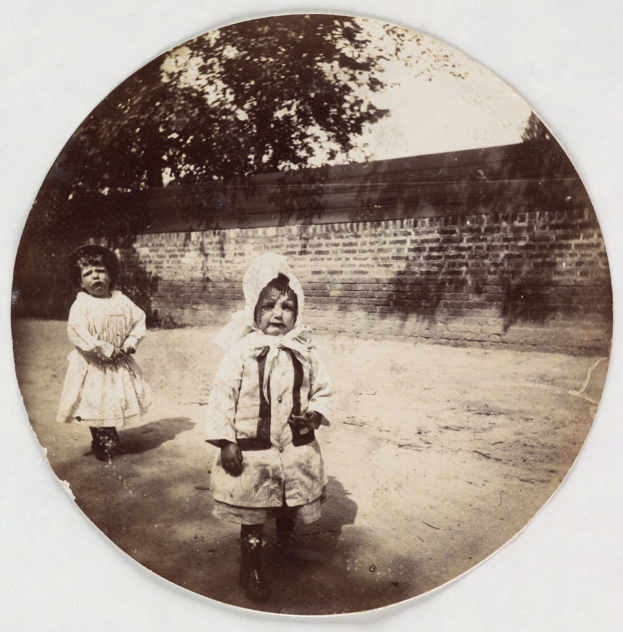 Zwei kleine Kinder gehen an einer Mauer entlang, um 1890 von Unbekannt