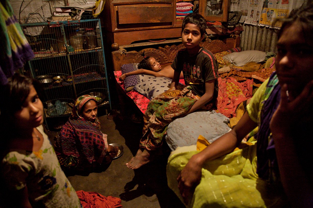 Eine Familie im Bambus-Slum-Wohngebiet, nahe dem Buriganga-Fluss, in Alt-Dhaka, Bangladesch. 21. Februar 2007. Bis zu 6 bis 10 Personen leben in 10x10 Fuß großen Räumen und teilen sich eine gemeinsame Handpumpe, Toilette und Küche. von Unbekannt Unbekannt