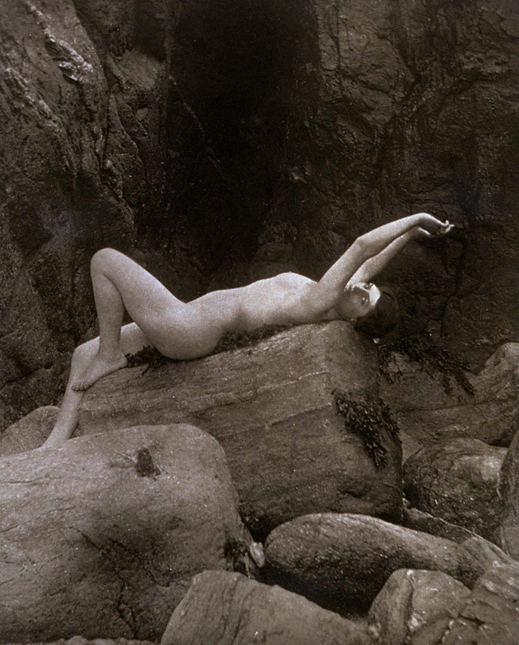 Eine nackte junge Frau in künstlerischer Pose auf einem Felsen liegend von Unbekannter Künstler
