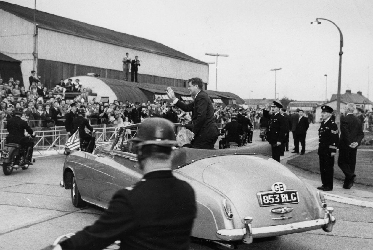 Nach der Inspektion einer Marine-Ehrenwache am Londoner Flughafen fahren Präsident Kennedy und Herr Macmillan in einem offenen Auto davon von Unbekannt