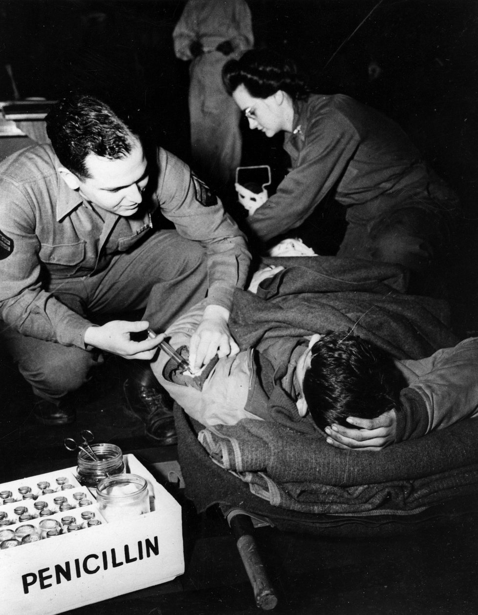 Zweiter Weltkrieg (1939-1945): Luxemburg Februar 1945: In einem Evakuierungskrankenhaus der US-Armee verabreicht ein Sanitäter (Krankenschwester) einem verletzten Soldaten Penicillin, um eine Infektion zu vermeiden, während eine Krankenschwester ihn für ei von Unbekannt