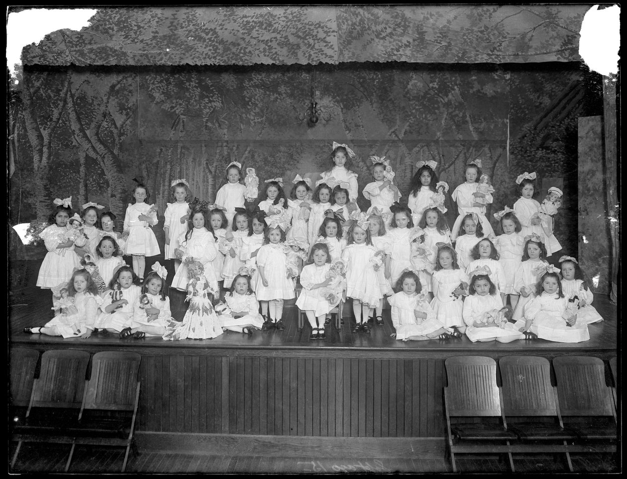 Gruppe kleiner Mädchen auf einer kleinen Bühne mit Puppen, wahrscheinlich das römisch-katholische Waisenhaus, Kingsbridge, Bronx, ca. 1911 von William Davis Hassler
