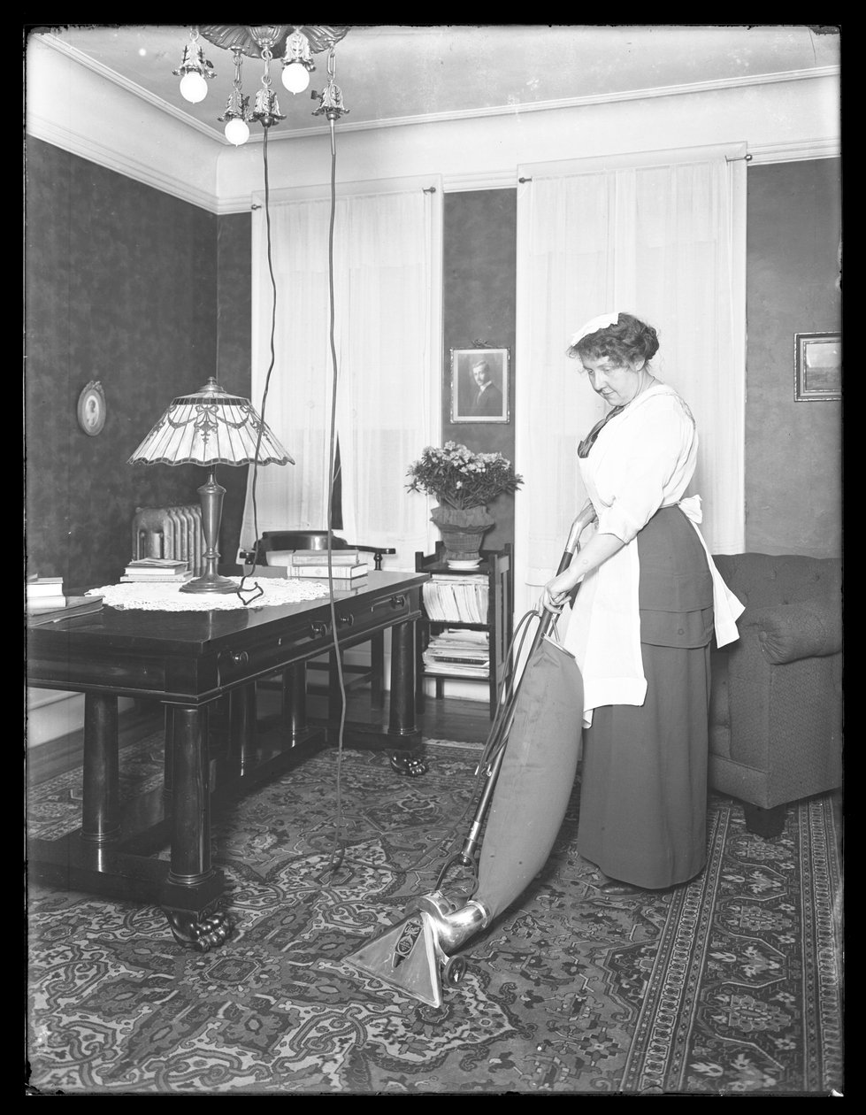 Unbekannte Frau demonstriert die Verwendung des Apex-Staubsaugers, ca. 1913-14 von William Davis Hassler
