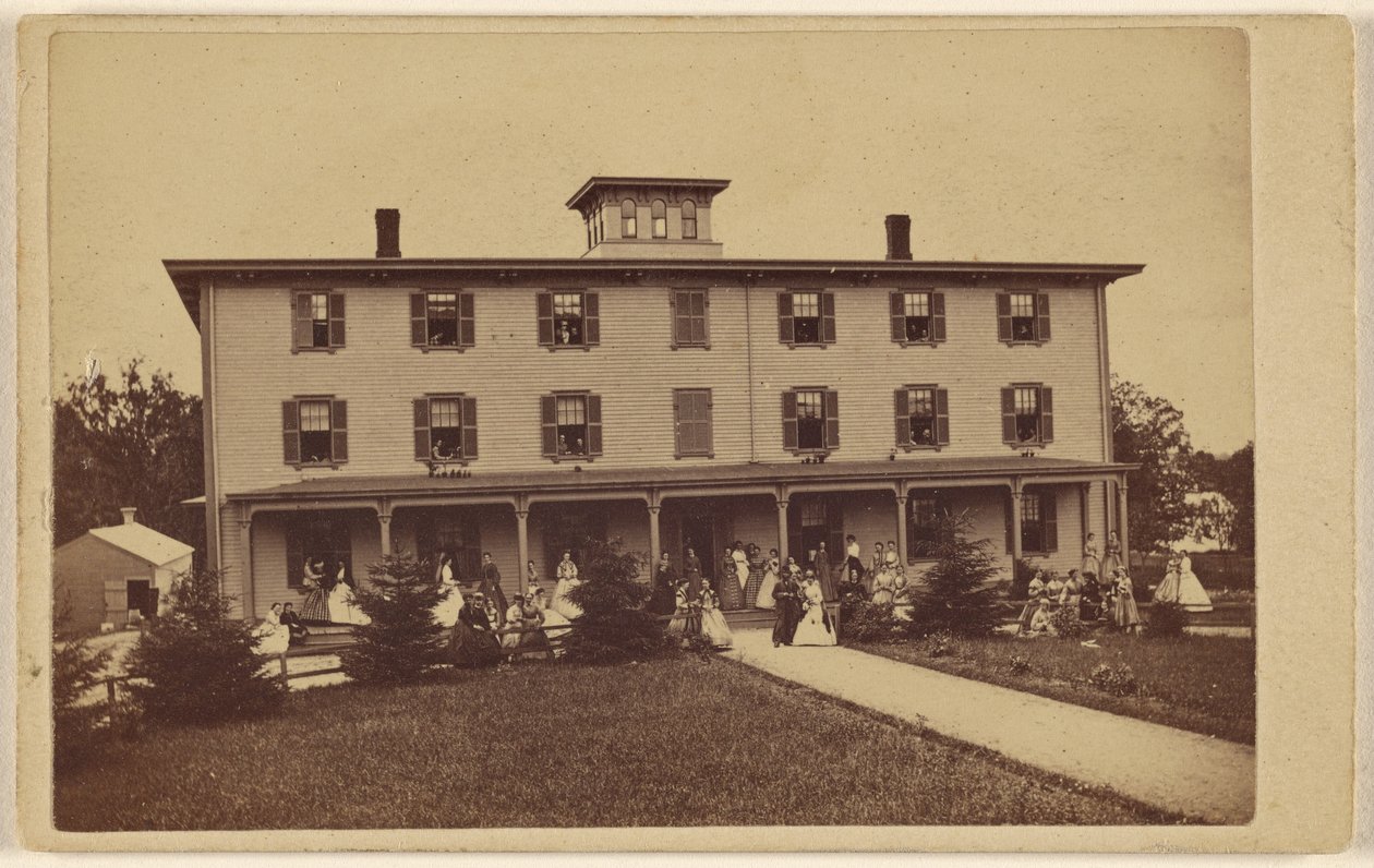 Ansicht eines Hauses mit zahlreichen Personen auf der Veranda und dem Rasen von Yeaw and Company