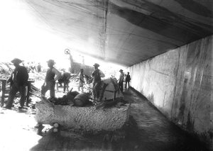 Arbeiter unter den Marmorwänden in einem Steinbruch, Apuanische Alpen (s/w Foto)