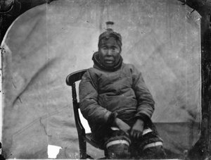 Eine ältere Inuk-Frau, die auf einem Stuhl sitzt