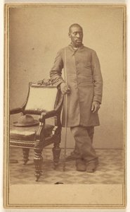 Schwarzer Soldat steht neben Stuhl mit Hut auf dem Sitz von Alexander Gardner