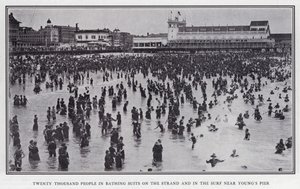 Zwanzigtausend Menschen in Badeanzügen am Strand und in den Wellen nahe Young