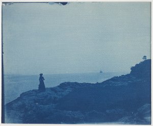 Frau beobachtet Schoner von einem felsigen Vorgebirge von American Photographer