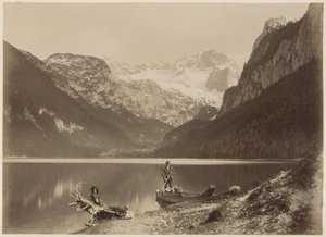 Blick auf einen See und umliegende Berge mit einem Mann im Vordergrund, der in einem Boot steht, vermutlich in den Alpen