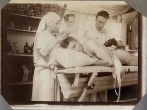 Erster Weltkrieg 1914-1918: Ärzte und Krankenschwester behandeln die Wunden eines Soldaten im Verbandsraum, Lager von Couville im Ärmelkanal, Untere Normandie, Frankreich. Anonyme Fotografie Juli 1917. Private Sammlung, Stella. von Anonymous Anonymous