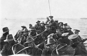 Blick nach achtern auf ein Rettungsboot mit unbekannten Männern der australischen 1. Divisional Signal Company, die um 6 Uhr morgens am Tag der Landung nach Anzac Cove geschleppt werden, 25. April 1915 (Schwarz-Weiß-Foto) von Australian Photographer