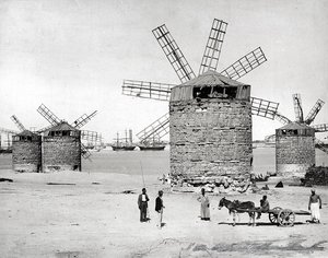 Windmühlen am Mittelmeer in Alexandria, Ägypten. Im Vordergrund posieren einige Ägypter mit einem kleinen Wagen von Brothers Zangaki