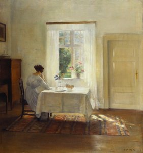 Eine Frau sitzt an einem Tisch am Fenster