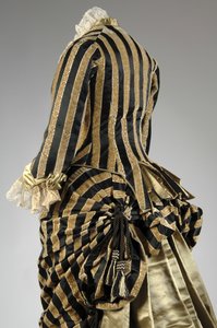 Abendkleid, ca.1884 (hintere schräge Teilansicht). Seidensatin und geschnittener Samt, Spitze, Seidenfadenquasten und Fransen. Charles Frederick Worth, Frankreich. von Charles Frederick Worth
