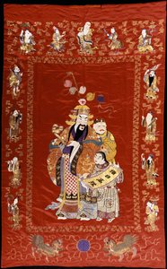 Ein chinesischer bestickter roter Satin-Wandbehang, der eine Figur mit einem Ru-i und zwei Begleitern darstellt, die Ränder dekoriert mit den acht Unsterblichen
