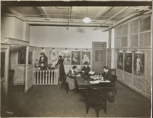 Hauptbüro/Empfangsraum bei der Mutual Film Co. mit Sekretärin am Schreibtisch, Menschen an einem Tisch beim Lesen und Porträts an der Wand, New York von Company Byron