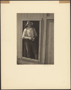 [Mann mit Strohhut in der Tür einer Scheune, der einen Tabakbeutel hält] von Doris Ulmann