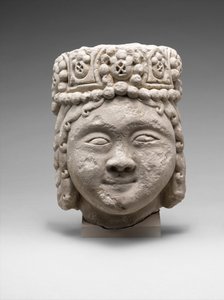 Kopf einer Figur mit Perlenkopfschmuck