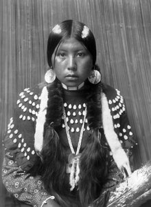 Kalispel-Indianerin, weiße Streifen auf dem Haar gemalt, Muschelscheiben-Ohrringe, trägt ein mit Elchzähnen verziertes Decken-Kleid, ca. 1910, Foto von Edward S. Curtis von Edward Sheriff Curtis