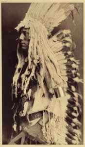 Alter Mensch, Piegan. Junge Männer verpassen keine Gelegenheit, bei öffentlichen Festen die Kleidung ihrer Krieger-Väter zu tragen. Foto aus Band 6 der Enzyklopädie von Edward S. Curtis (1868-1952) über die Indianer Nordamerikas